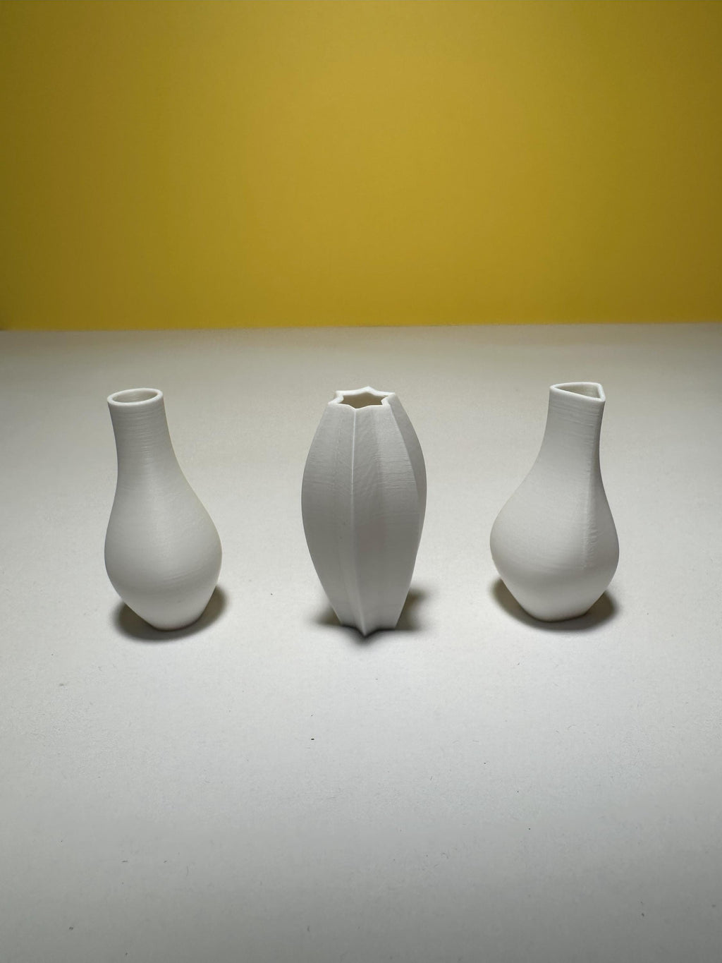 Three white sculptural dollhouse vases with a smooth matte finish